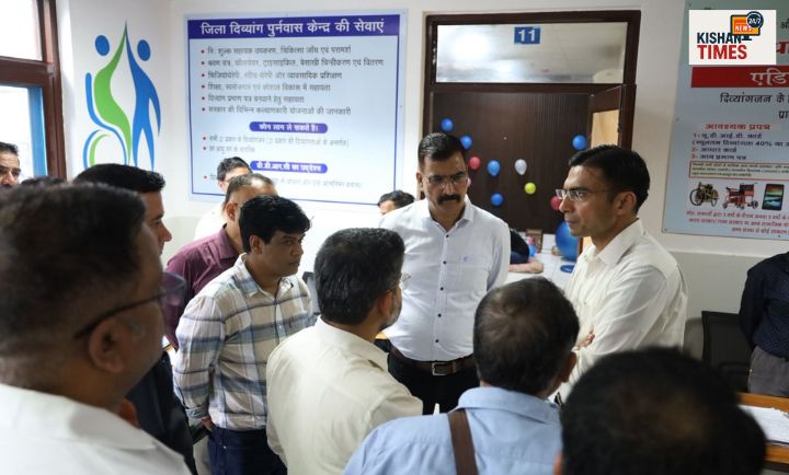 दिव्यांगजन को कृत्रिम अंग और सहायक उपकरण वितरित करते अधिकारी"