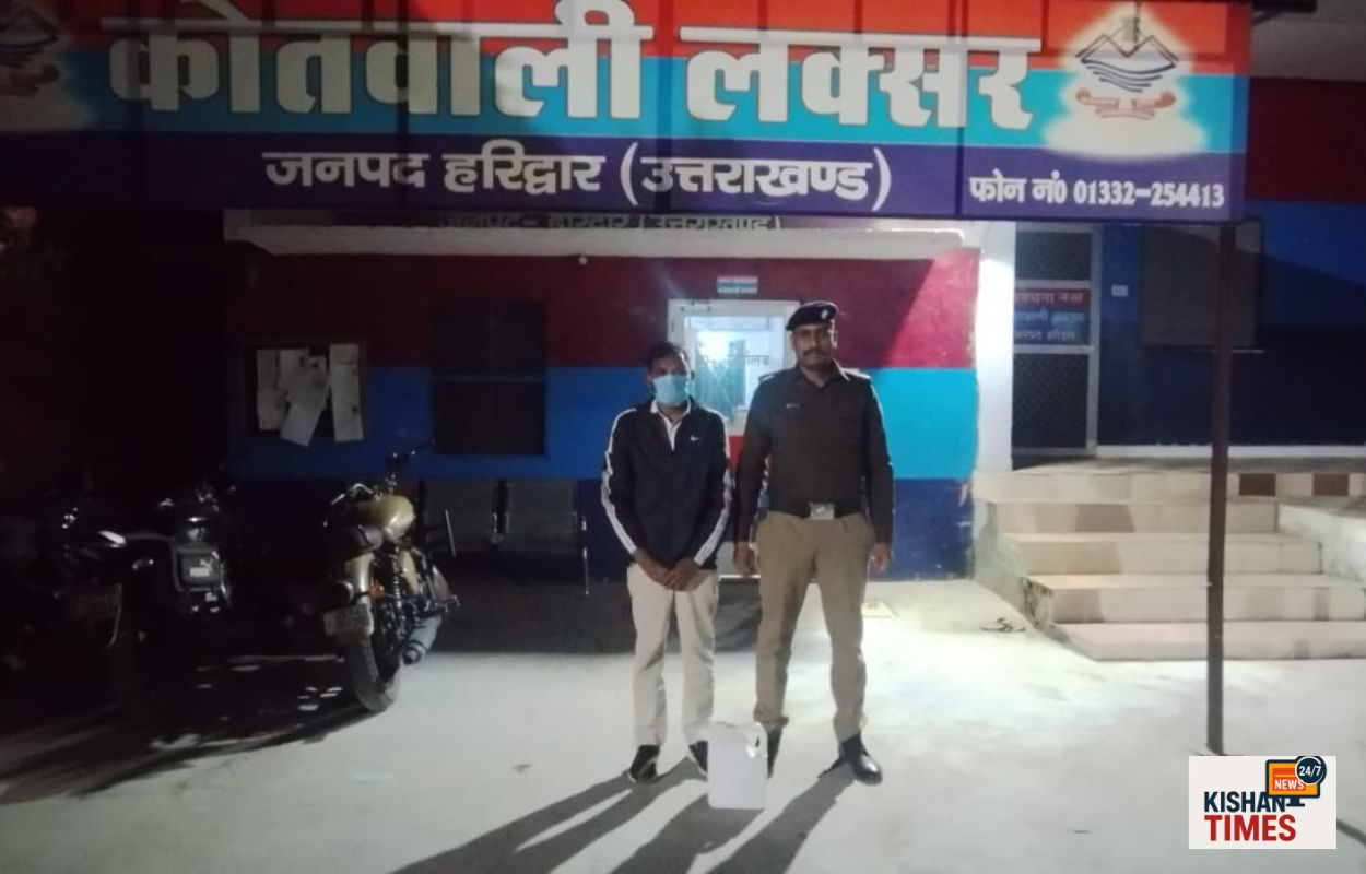 “लक्सर पुलिस द्वारा अवैध कच्ची शराब के साथ पकड़ा गया आरोपी और जब्त शराब की बोतलें।”